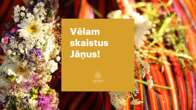 Ziedu vainags uz tautiskiem, sārtiem, svītrainiem svārkiem