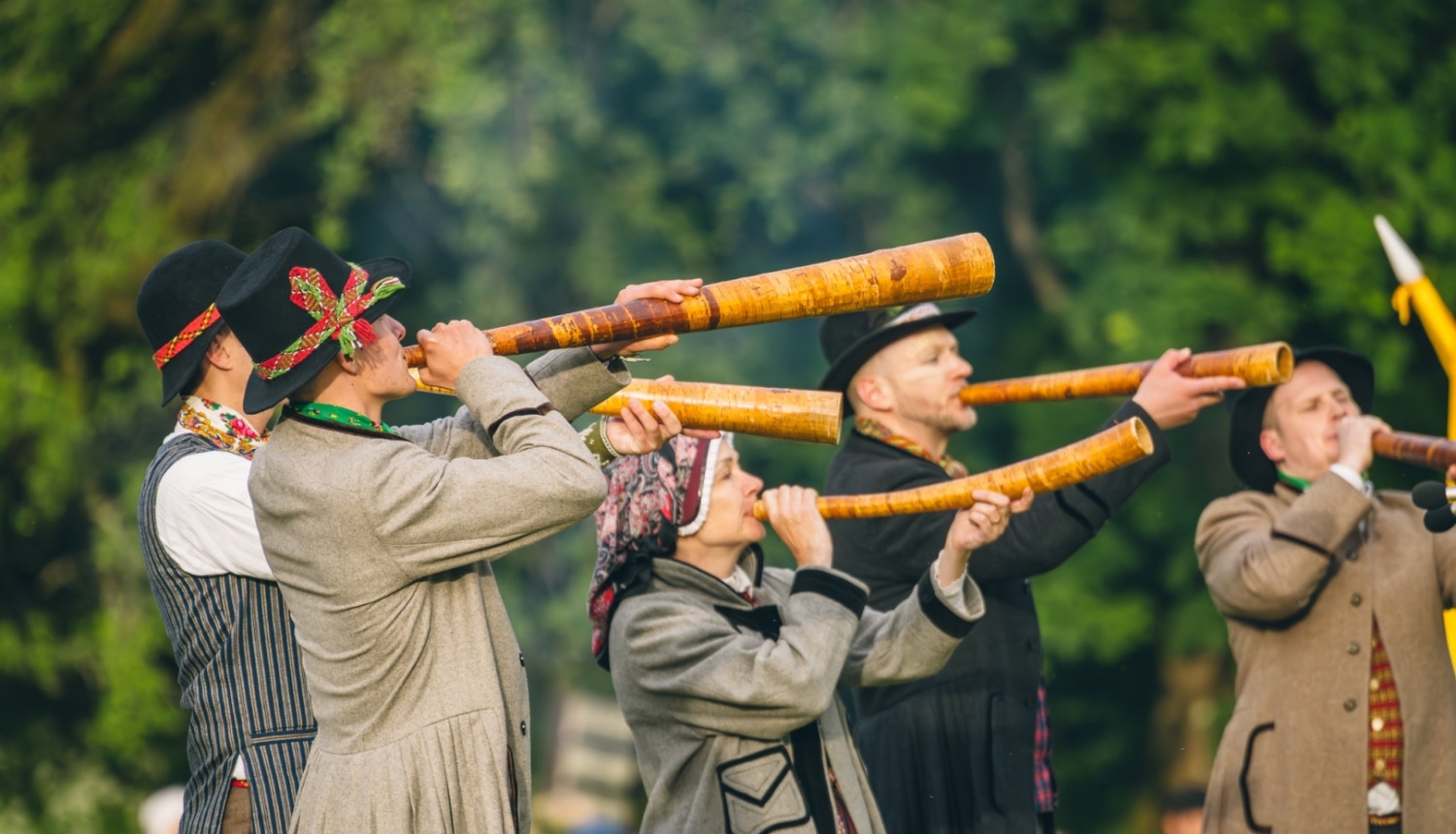 Folkloras festivāla Baltica dalībnieki ir ģērbušies tradicionālā tautastērpā spēlē koka pūšaminstrumentus
