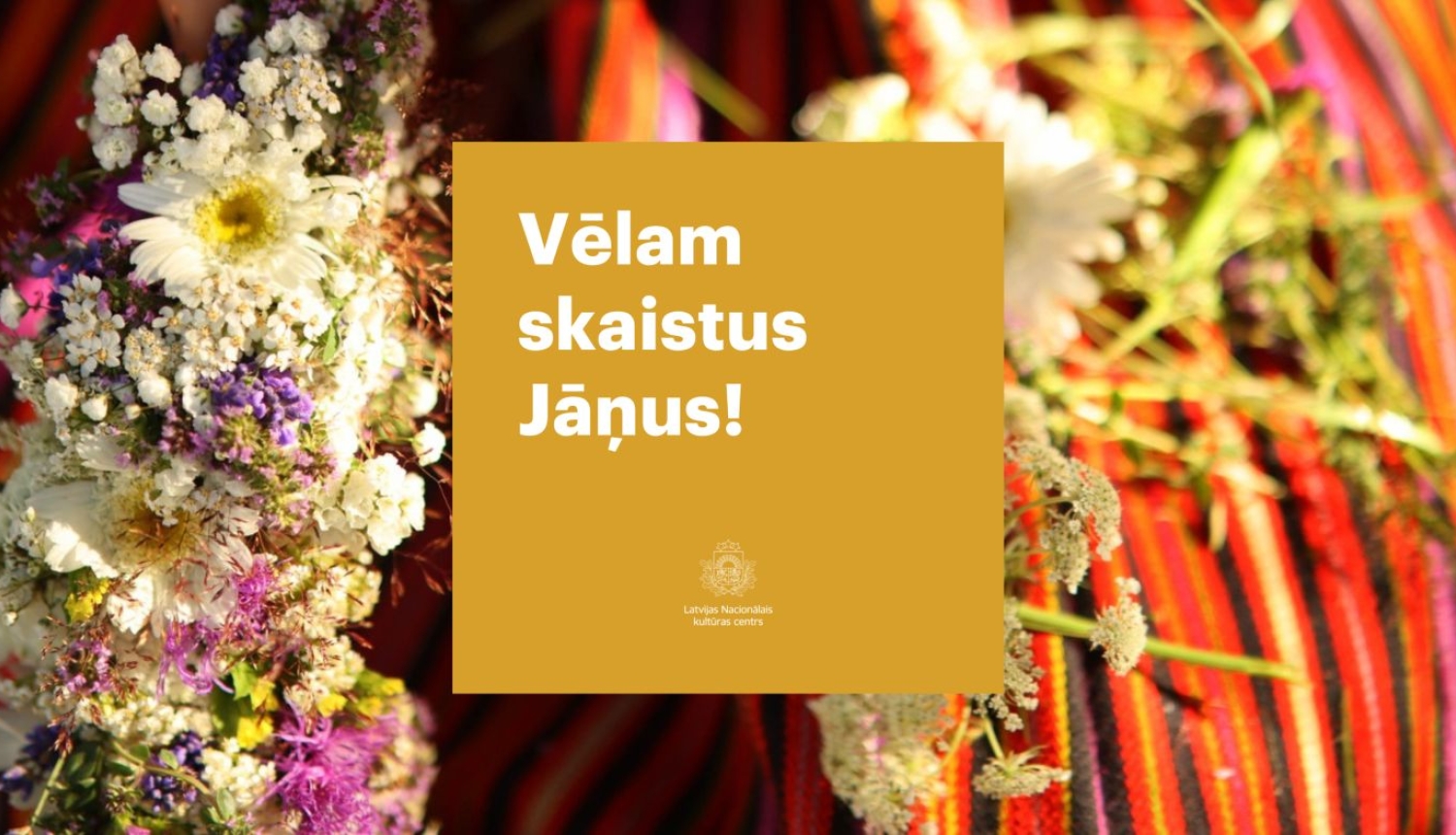 Ziedu vainags uz tautiskiem, sārtiem, svītrainiem svārkiem