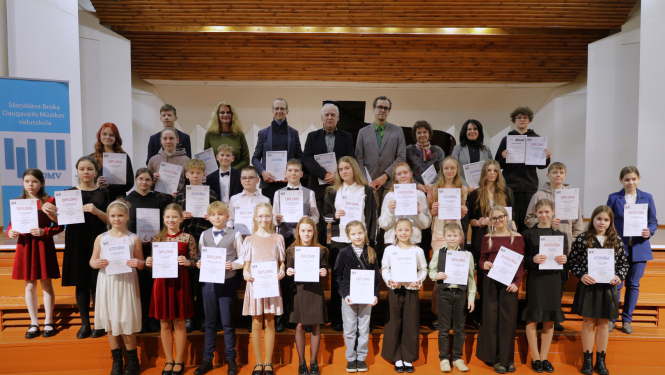 Klavierspēles konkursa dalībnieki un žūrija stāv uz skatuves podestiem