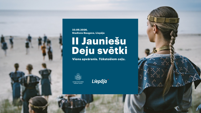 Deju kolektīva dalībnieki zilas krāsas tautas tērpos pie jūras