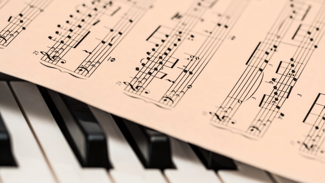 uz klavieru taustiņiem uzlikta nošu lapa