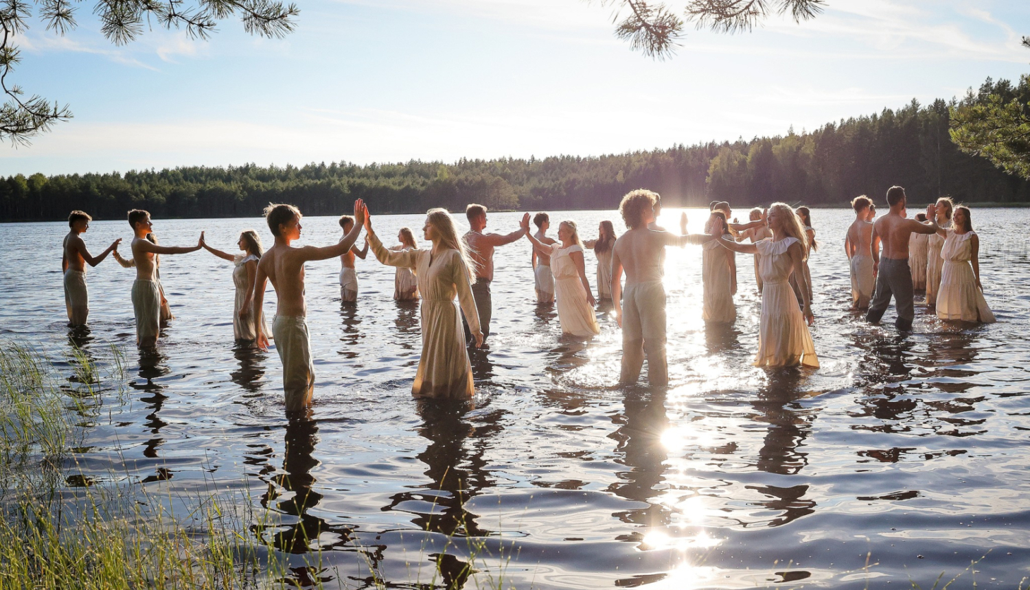 Dejotāji ezerā saulrietā