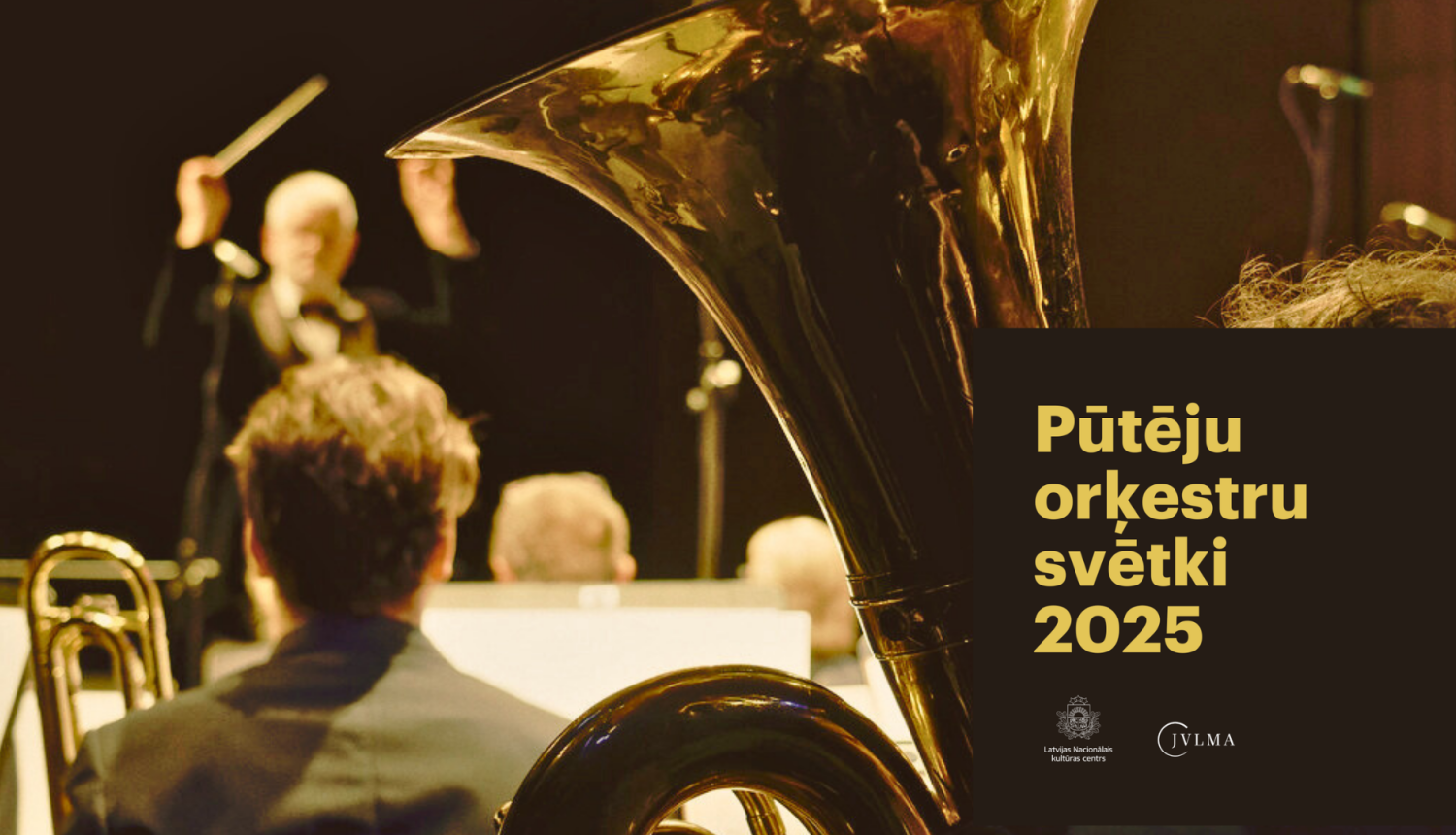 Pūtēju orķestris ar tubu priekšplānā un diriģentu fonā