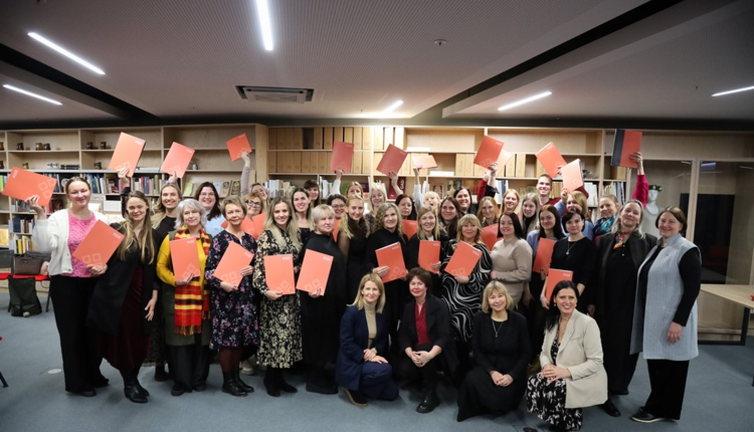 Dziesmu svētku telpā, Mežaparkā, kultūras speciālisti vienojušies kopbildē pēc profesionālās pilnveides kursu pabeigšanas. Visi tur rokās kursa sertifikātu.
