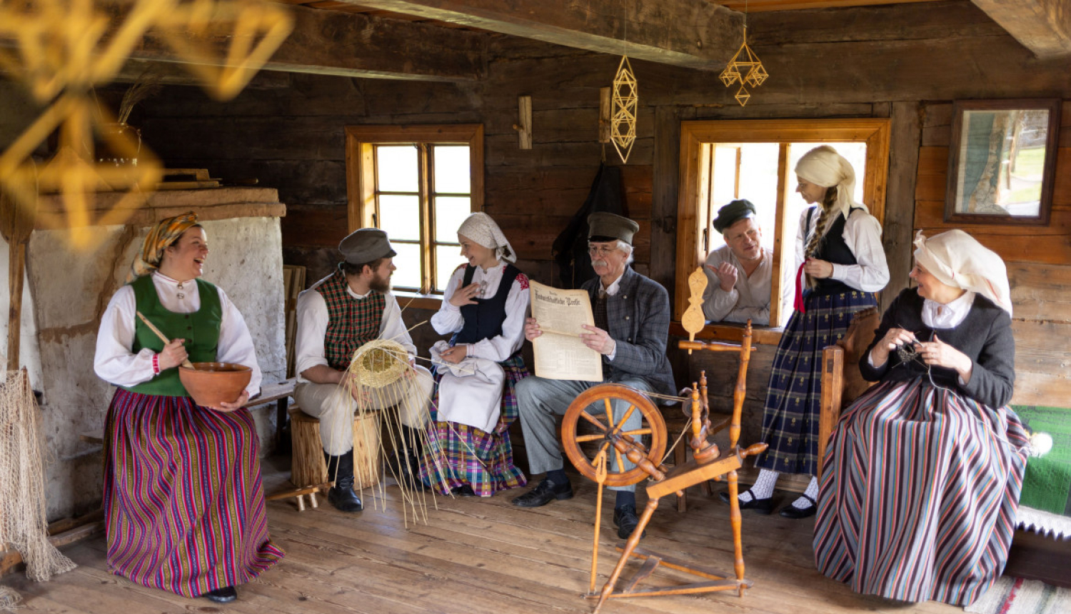 Cilvēki, tērpi tautastērpos, atrodas vienā no brīvdabas muzeja ēkām