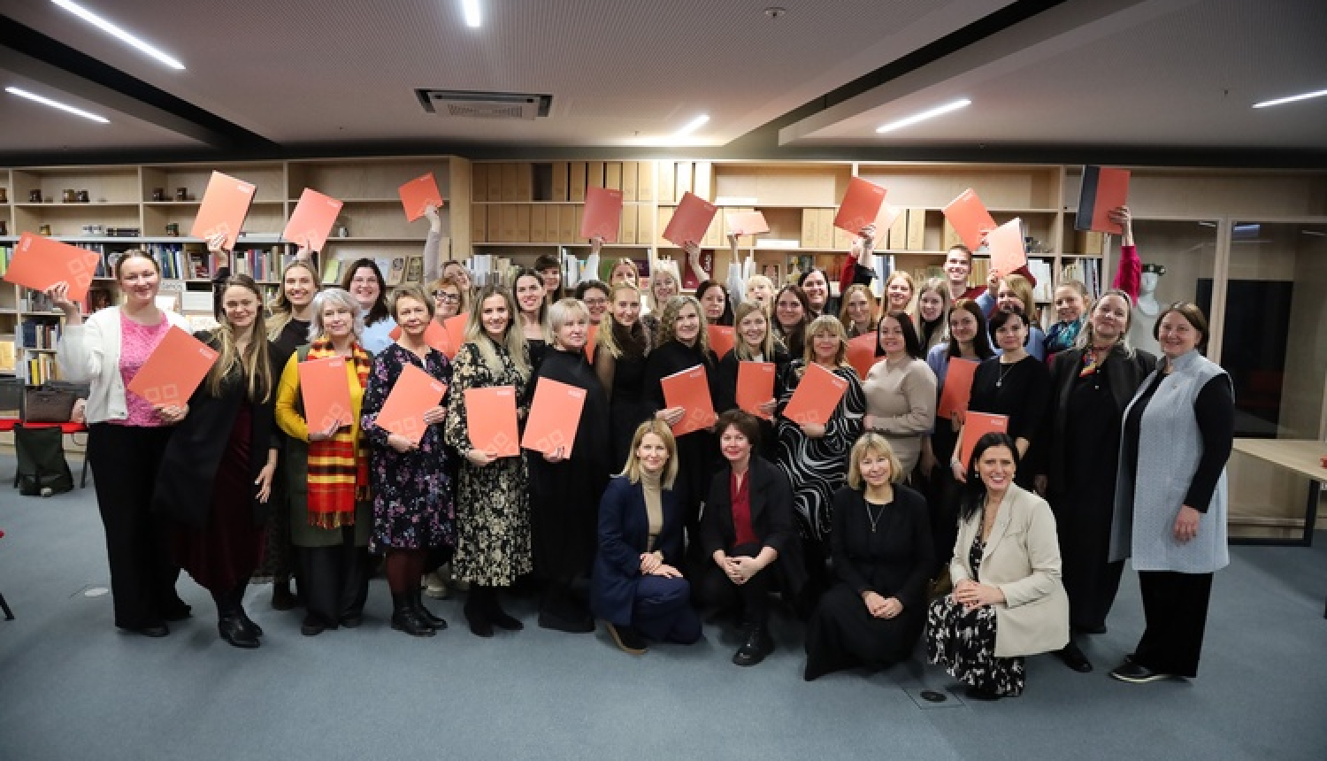 Dziesmu svētku telpā, Mežaparkā, kultūras speciālisti vienojušies kopbildē pēc profesionālās pilnveides kursu pabeigšanas. Visi tur rokās kursa sertifikātu.